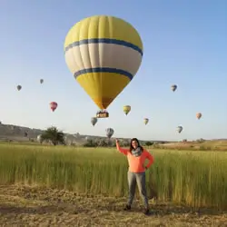 Smiling tourist with hot air balloon at sunrise in Cappadocia