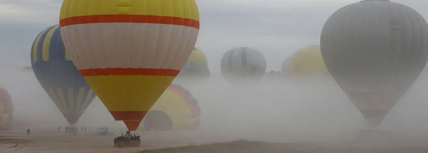 Hot air balloons waiting to launch on a foggy autumn morning in Cappadocia